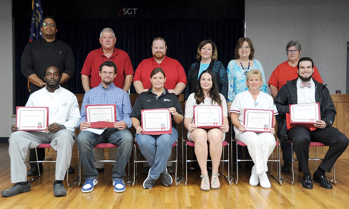 Seated from left to right are nominees Terrence Turner, Casey Rucker, Jessica Mourey, Ashley Buford, Lisa McClendon, and Noah McCleskey. Standing from left to right are nominating instructors Johnny Davis, Mike Enfinger, Deryk Stoops, Vickie Gilbert, Cathy Freeman, and Brenda Gilliam.