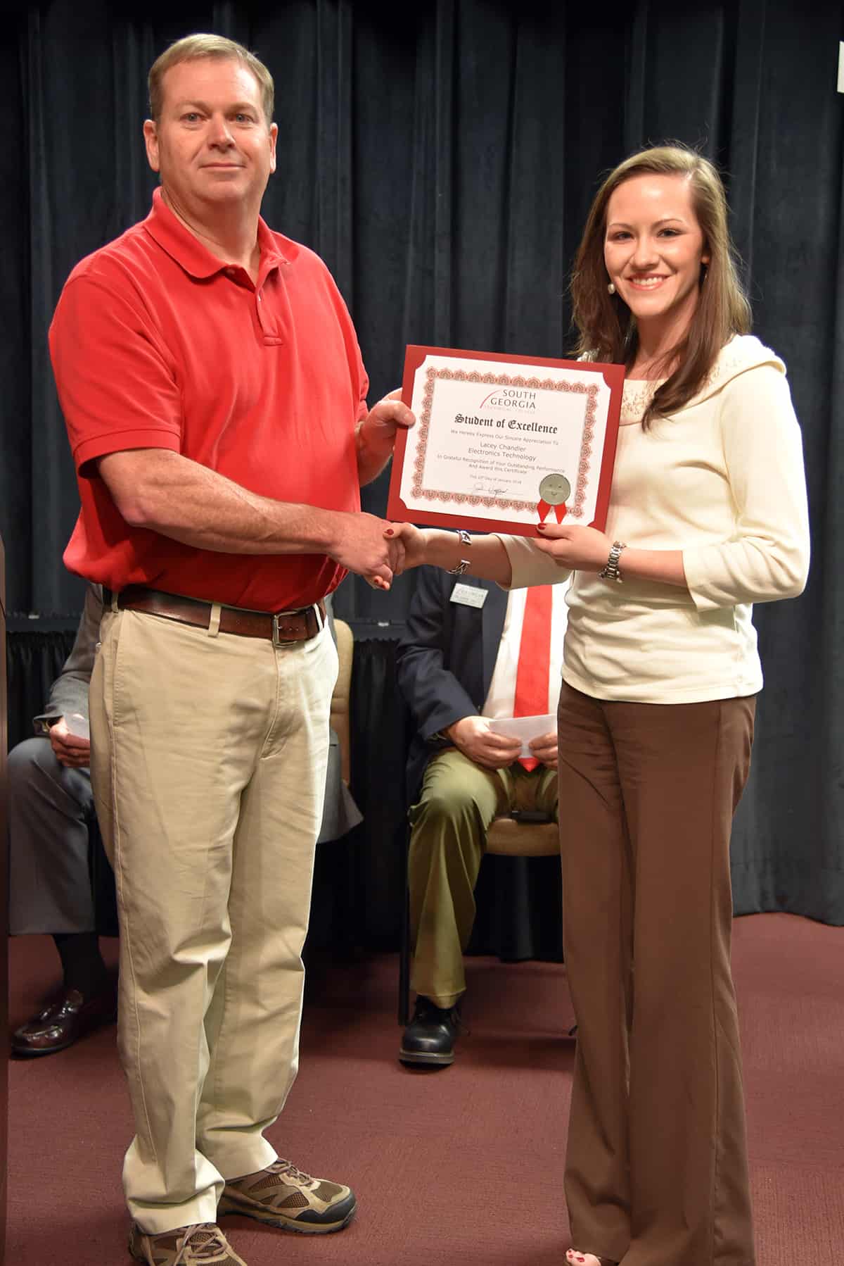 Lacey Chandler accepts her nomination certificate from nominating instructor Mike Collins.