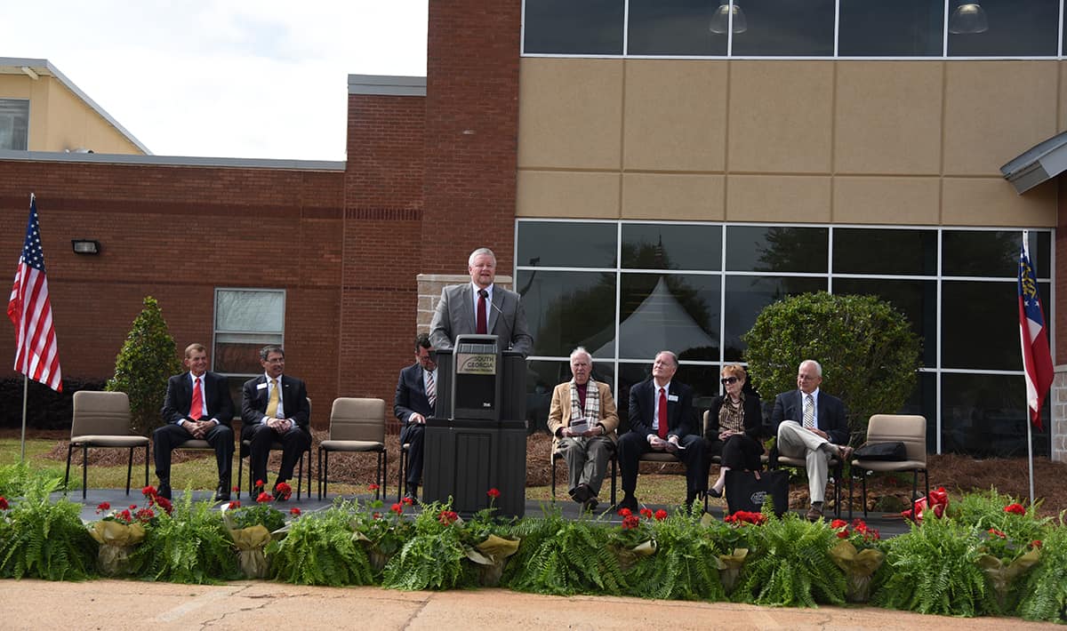 SGTC Commissioner Matt Arthur delivered the key note address at the South Georgia Tech Morgan Diesel and Automotive Complex ribbon cutting.  Also shown are SGTC President Emeritus Sparky Reeves, Mike Cheokas, Dr. John Watford, Rev. Bill Dupree, Don Smith, Marcia Morgan Wright, and David Morgan on the stage.