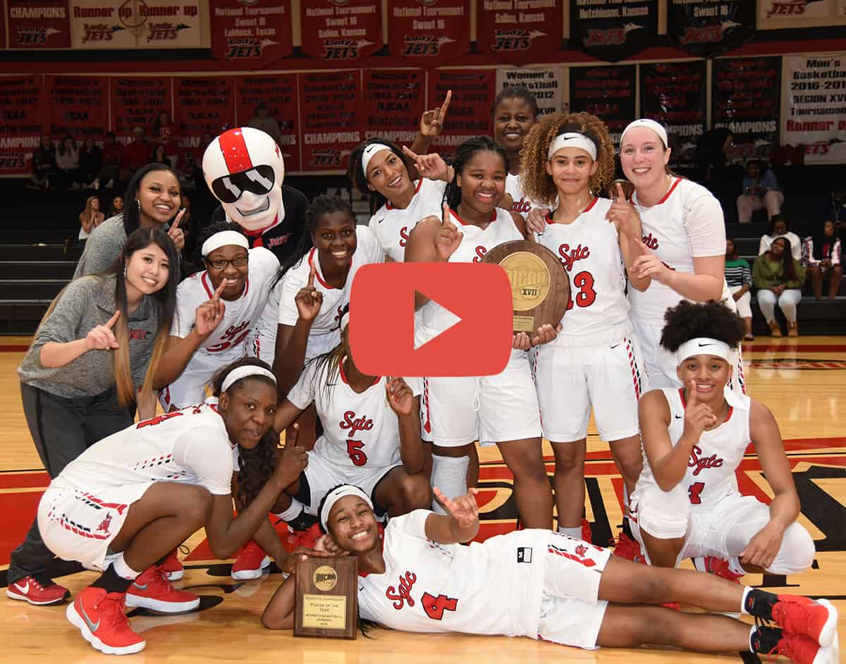 Lady Jets posing for a picture with their Region XVII plaque with an overlayed image of a YouTube "play" button.