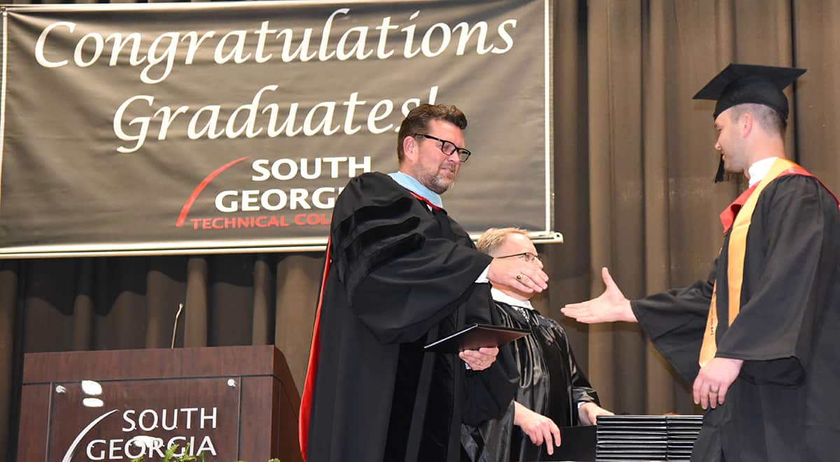 South Georgia Technical College President Dr. John Watford is shown above presenting Presidential Honor Graduate Logan Boyd with his associate of applied science degree.  Boyd is a member of the college’s first Caterpillar Electrical Power Generation Dealer Service Technology program graduating class.  This is the first program of its type in the world for Caterpillar.