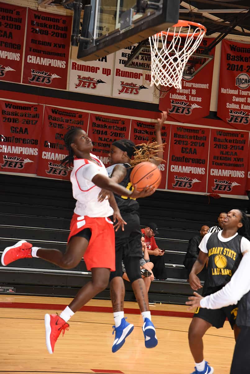 Fatou Pouye, 12, a sophomore from Kaolack, Senegal, came away with 11 points against Albany State.  She is shown driving under the basket for a reverse layup.