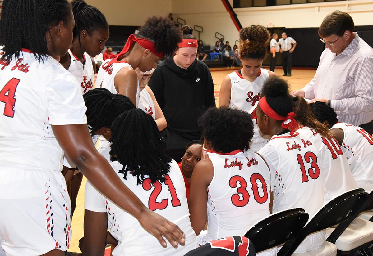 Lady Jets Assistant Coach Kenzia Conyers is shown talking with the team during a time-out.