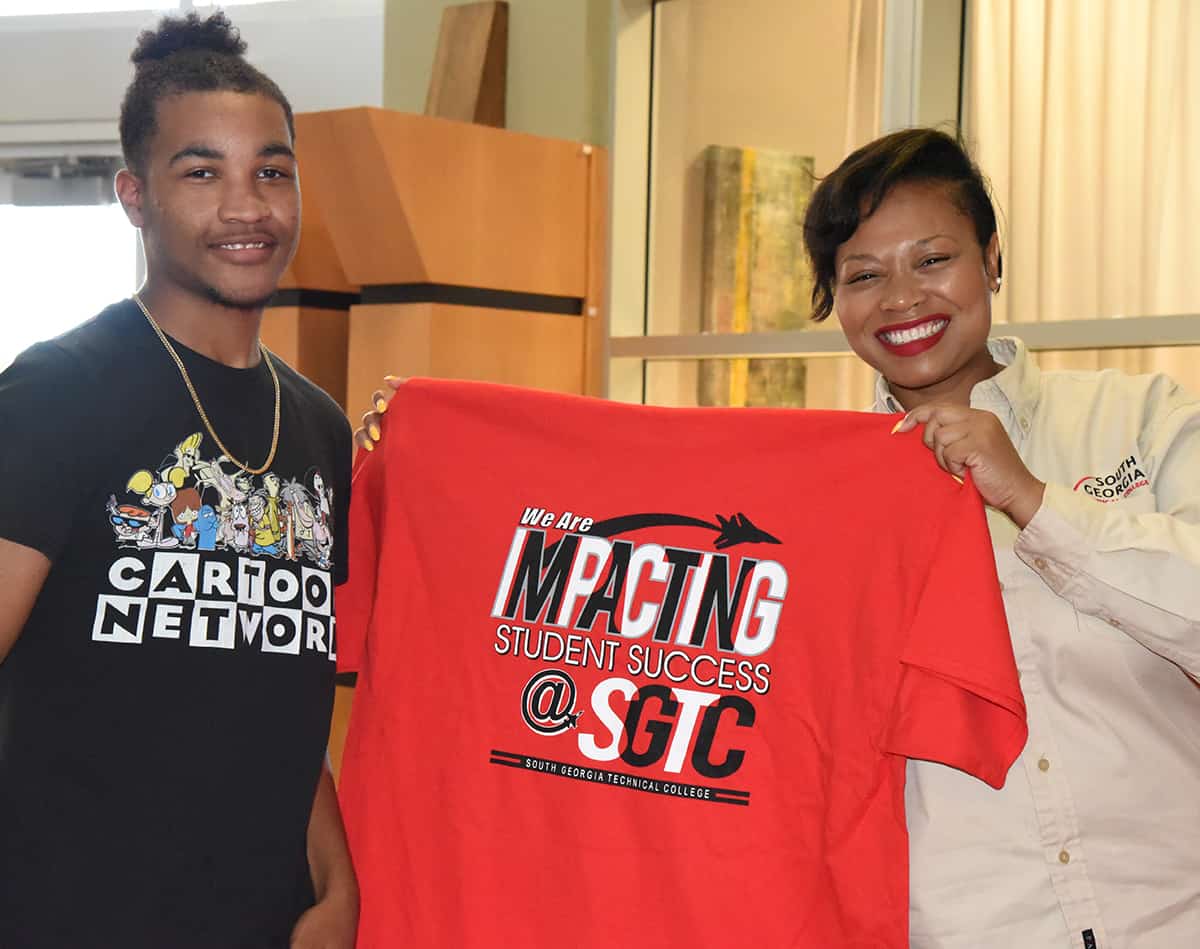 SGTC English Instructor Raven Payne is shown presenting a new Fall Semester student with an Impacting Success t-shirt at the July 17th registration day event.