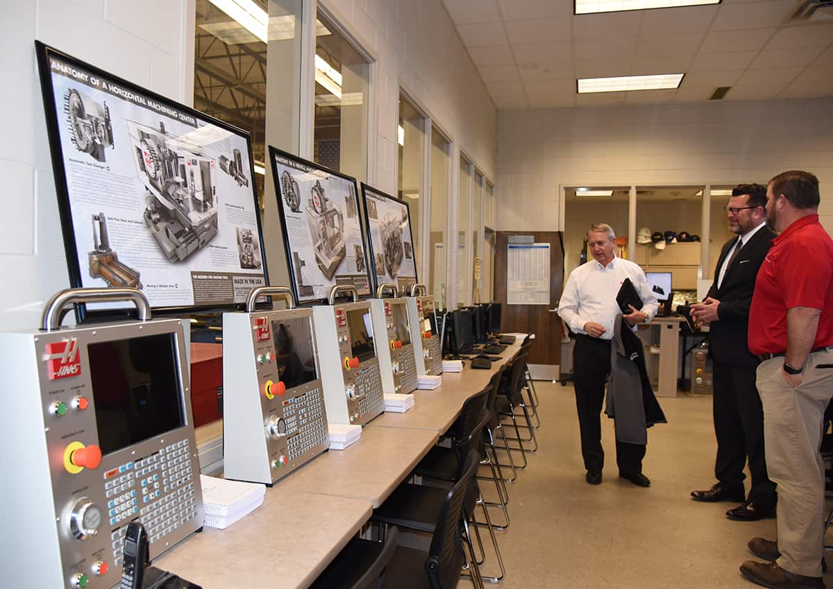 Chad Brown is showing Dr. Watford and David Aycock some of the new equipment that he has added to his classroom area.