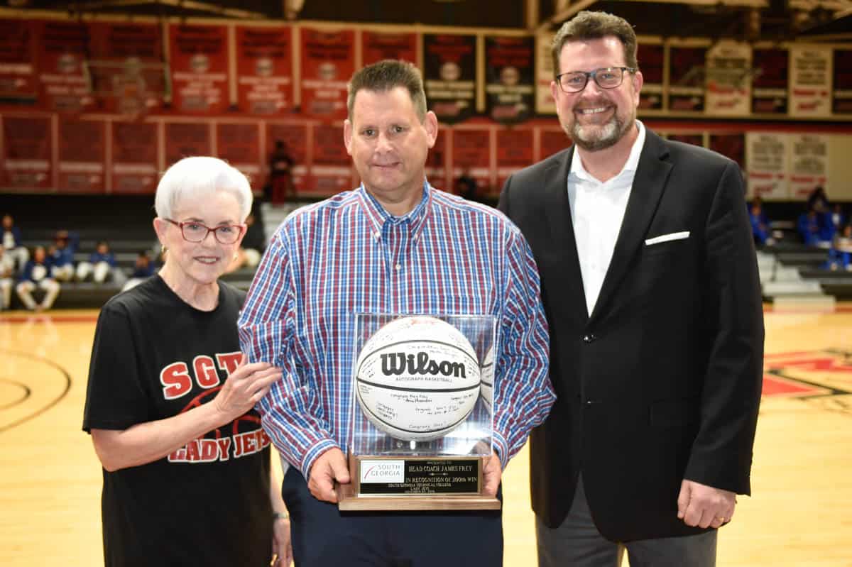 James Frey (center) accepts a commemorative game ball in recognition of his 200th win as Head Coach of the SGTC Lady Jets basketball team. Presenting the ball were Jets Booster Club President Martha Arrington and SGTC President Dr. John Watford.