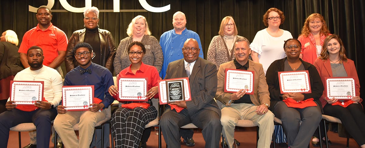 Shown above (l to r) are the student nominated for the SGTC Student of Excellence for February.
On the front row are: included Geoffrey Glover of Cordele, Barbering; Tyras Washington of Fitzgerald, Cosmetology; Trenidee Sanford of Americus, Criminal Justice Technology; Roderick Douglas of Americus, Culinary Arts; Edwin Cabrera of Americus, Early Childhood Care and Education; NaBryia Denson of Americus, Medical Assisting; and Sierra Berry of Americus, Practical Nursing.  On the back row are their instructors: Xavier Jackson, Barbering; Dorothea Lusane McKenzie, Cosmetology; Teresa McCook, Criminal Justice; Chef Ricky Watzlowick, Culinary Arts; Jay Cripe, Early Childhood Care and Education; Jeana Yawn, Medical Assisting; and Jennifer Childs, Nursing.
