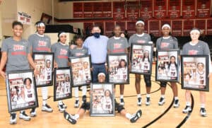 SGTC Lady Jets head coach James Frey is shown above (center) with his nine sophomores.  They are (l to r) Niya McGuire, Hope Butera, Imani McNeal, Veronica Charles, Flore Ngasamputu, Femme Sikuzani, Sarah Lwambo and Moe Shida.  Seated in front of Coach Frey is Kamiya Hollingshed.