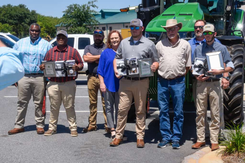 A few of the SGTC John Deere Agricultural Technology students pose for a photo with their family members after a recent ceremony on the SGTC campus to recognize new graduates from the program.