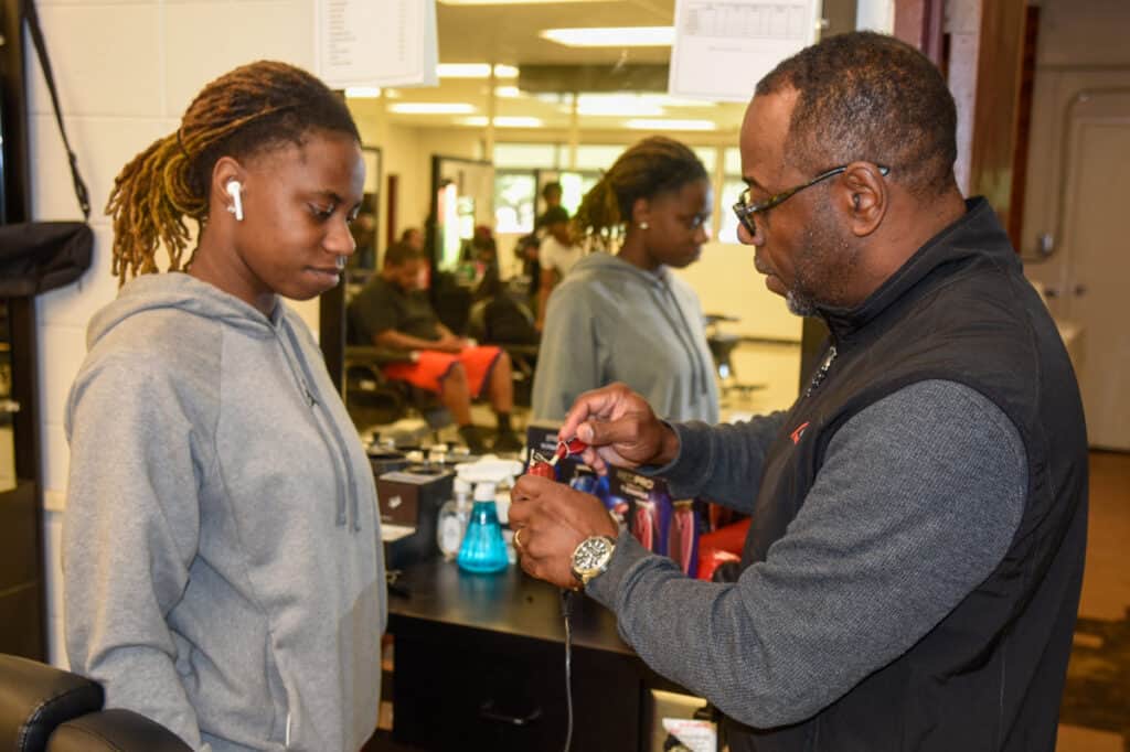 SGTC Barbering Instructor Andre Robinson is shown above (right) with one of his students and the Red Pro Titanium Clippers.