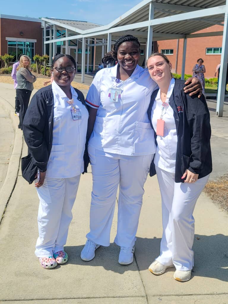 Three female nursing students smiling for the camera