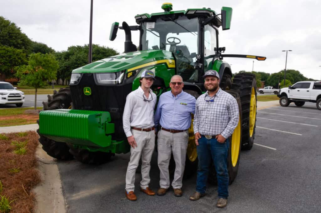 Grads beside tractor