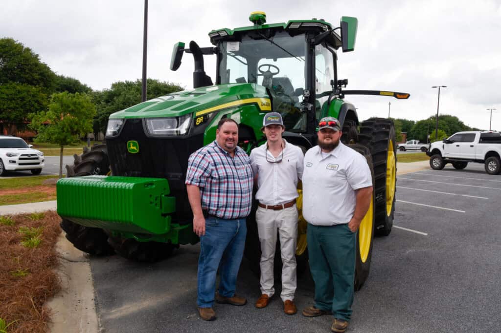 Grads beside tractor