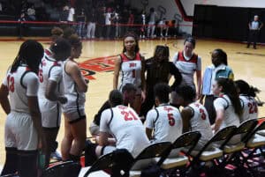 The Lady Jets huddle together during a timeout.